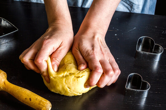 cooking homemade cookies with hands on dark background