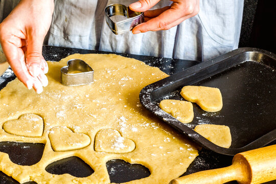 cooking homemade cookies with hands on dark background