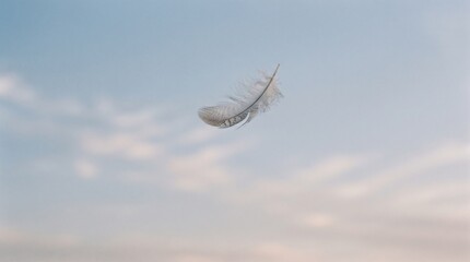 White feather drifting gracefully in clear blue sky with soft clouds during daytime flight © Ali