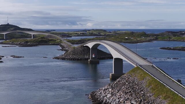 Aerial view of the curved Storseisundet Bridge along the iconic Atlantic Ocean Road connecting small rocky islands in Norway.