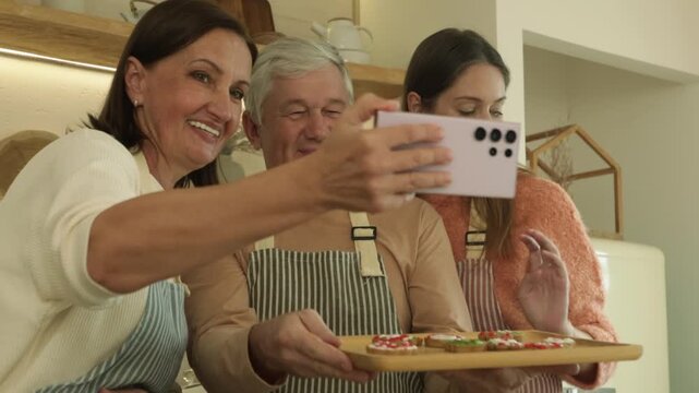 Family consisting parents and their beautiful daughter holding colorful cookies posing  smartphone photo the beauty smiles enjoy baking together joyful christmas day.