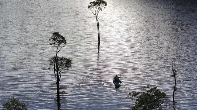 Aerial drone view of visitors kayaking and making coffee at sunrise on Suoi Tia, Tuyen Lam Lake in Xuan Huong, Da Lat, Vietnam, enjoying a peaceful morning in nature.