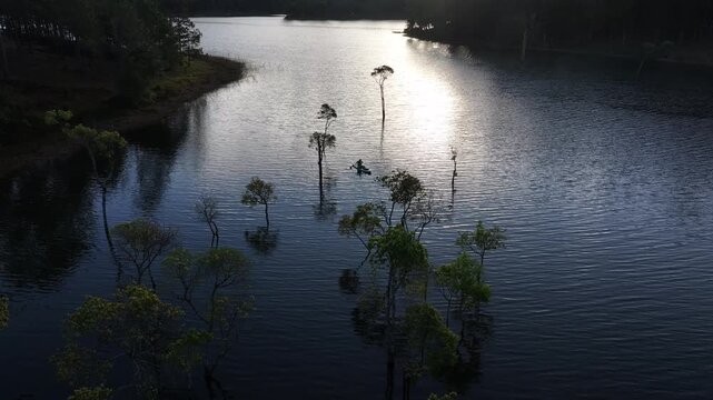 Aerial drone view of visitors kayaking and making coffee at sunrise on Suoi Tia, Tuyen Lam Lake in Xuan Huong, Da Lat, Vietnam, enjoying a peaceful morning in nature.
