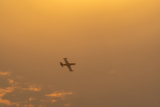 View of a Soko G-2A Galeb aircraft performing at the Antidotum Airshow against a golden sunset sky in Leszno, Greater Poland Voivod, Poland.