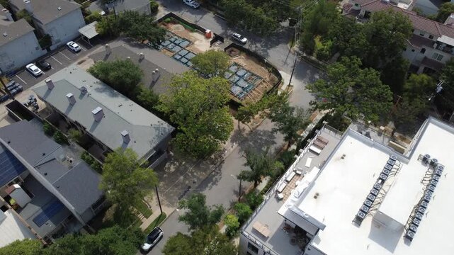 Mounted HVAC chillers top flat modern roofs along Congress Avenue in Dallas. Surrounding pitched shingle residences highlight dense urban living expansion across DFW Metroplex, Texas