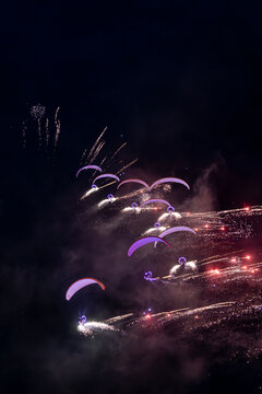 View of paragliders performing with pyrotechnics and lights during the Antidotum Airshow at night at Leszno Airport, Leszno, Wielkopolskie, Poland.