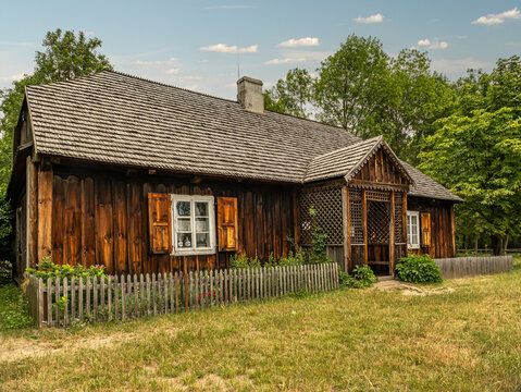 Rustic Wooden Cottage With Shuttered Windows and Picket Fence in Lush Rural Setting
