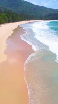 Vertical aerial view of Grande Anse on Mahe Island in Seychelles showing turquoise water, white sand and lush tropical coastline.