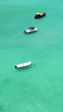 Vertical ascending aerial view over Port Launay in Seychelles revealing turquoise water, tropical coastline, lush vegetation and scenic island landscape.