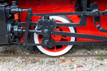 Steam locomotive wheel with rod and crankpin visible. Valve gear and piston linkage near cylinder on metal frame for technical reference and restoration. © Mati