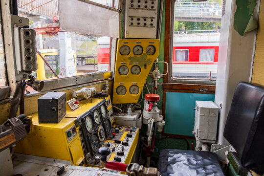 View of the interior of a vintage train locomotive cab at Railway Park featuring analog gauges, control levers, and a yellow dashboard in Vilnius, Vilniaus apskritis, Lithuania.