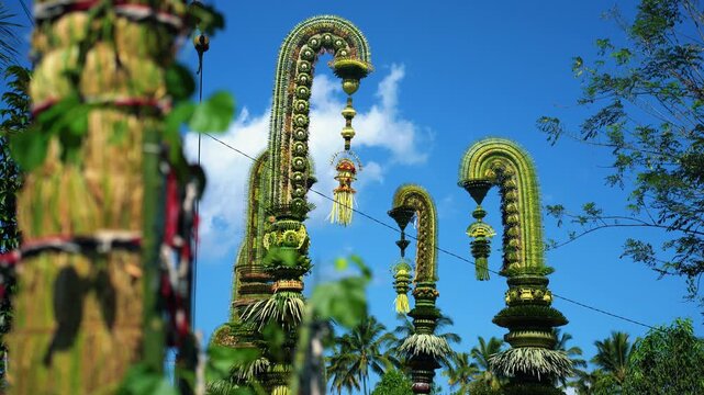 Tall decorative bamboo pole penjor erected for Galungan Hindu festival along street, Bali, Indonesia