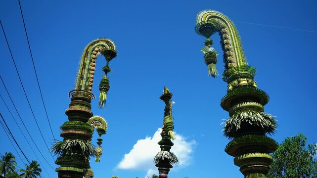 Tall decorative bamboo pole penjor erected for Galungan Hindu festival along street, Bali, Indonesia