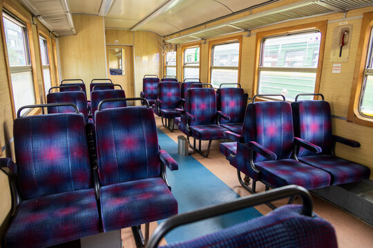 View of the interior of a train carriage with rows of blue and purple patterned seats and wooden window frames in Railway Park, Vilnius, Vilniaus apskritis, Lithuania.