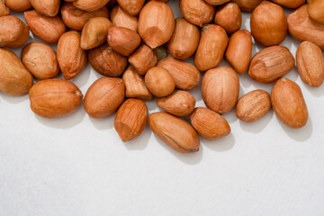 Obraz premium Raw peanut kernels in brown peel in close-up White Background