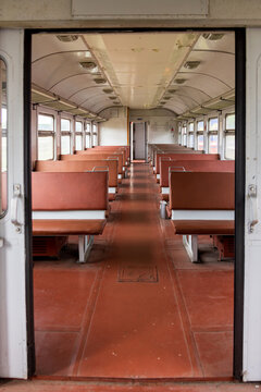 View of the interior of a vintage train carriage with brown leather seats, a central aisle, and large windows in Railway Park, Vilnius, Vilniaus apskritis, Lithuania.