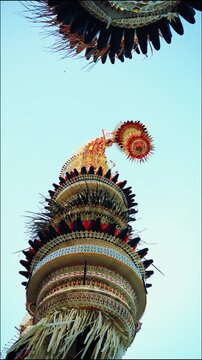 Tall decorative bamboo pole penjor erected for Galungan Hindu festival along street, Bali, Indonesia