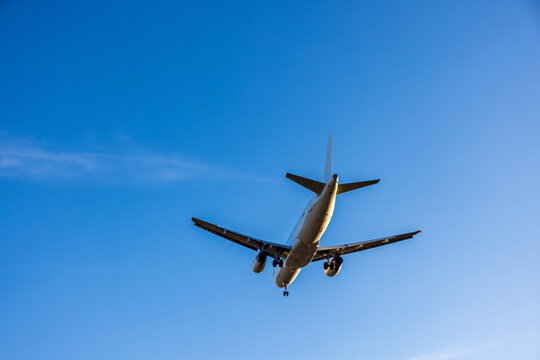 View of a commercial airplane flying against a clear blue sky in Vilnius, Vilniaus apskritis, Lithuania.