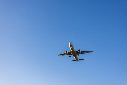 View of a passenger airplane approaching Vilnius International Airport against a clear blue sky in Vilnius, Vilniaus apskritis, Lithuania.