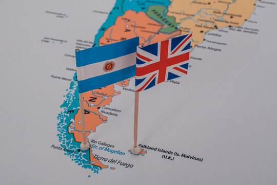 Miniature flags of Argentina and Great Britain pinned on a map over Argentina and the Falkland Islands.