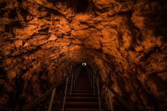 View of the interior of a cave at French Mountain with a staircase leading towards the light, featuring rugged rock walls and natural textures in Antsiranana, Diana, Madagascar.