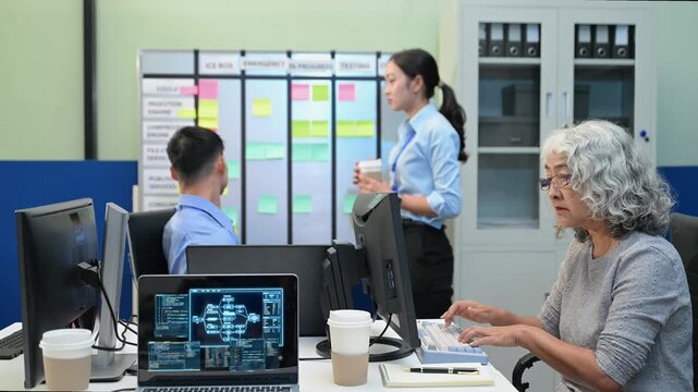 Asian software developers and engineers planning workflow on an agile scrum board with sticky notes