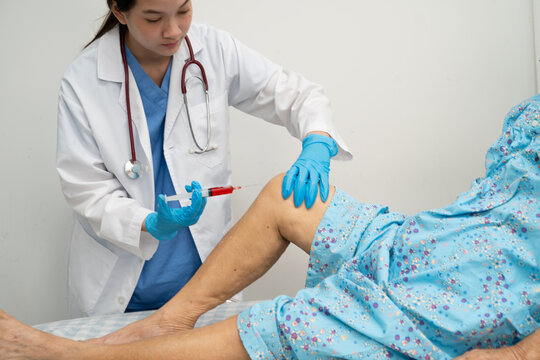 Asian doctor inject Hyaluronic acid platelet rich plasma into knee of senior woman.