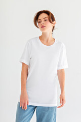 Obraz premium Blank white t-shirt mockup on woman standing in studio