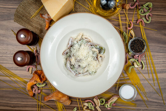 Wild mushroom pasta topped with parmesan cheese, food flat lay, top-view on a rustic wooden table