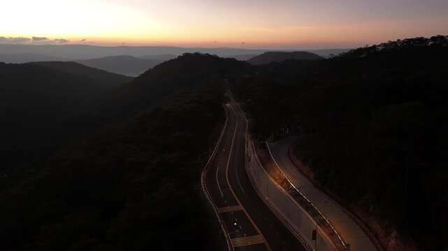 Aerial drone view of Prenn Pass winding through lush pine forests and mountains in Xuan Huong Ward, Da Lat, Lam Dong Province, Vietnam.