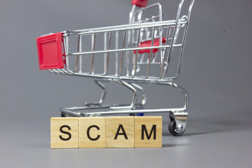 Shopping cart with a note labeled SCAM, symbolizing illegal markets, fraudulent transactions, consumer deception, financial loss, shopping risks, legal consequences, law enforcement, and awareness of  © bizdof photo