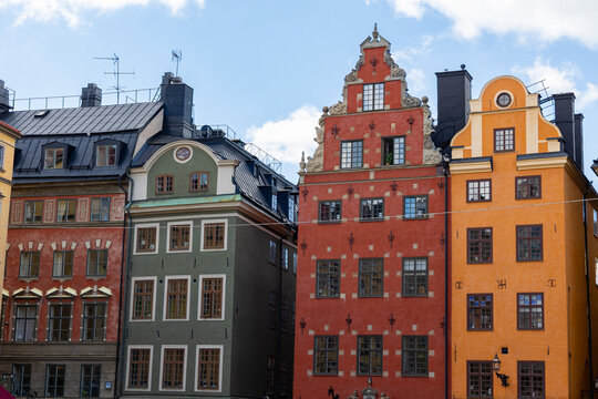 View of colorful historic buildings in Gamla Stan with distinct gabled facades and vibrant red, green, and orange paint in Stockholm, Stockholm County, Sweden.