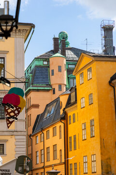 View of colorful historic buildings in Gamla Stan with yellow facades and copper roofs in Stockholm, Stockholm County, Sweden.