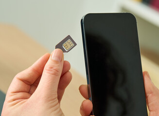 Naklejka premium Close up of a woman hands putting the sim card on the phone on a table