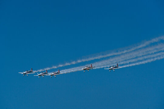 View of Team Raven performing a formation flight with Van's RV-8 aircraft leaving smoke trails against a clear blue sky at the Antidotum Airshow in Leszno, Greater Poland Voivod, Poland.