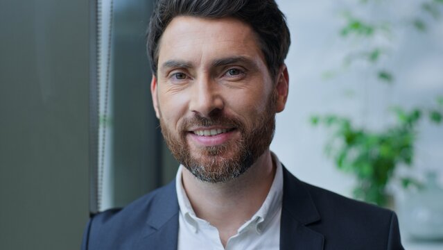 Close up Caucasian middle-aged business man looking at camera smiling happy cheerful posing in office optimistic 40s leader lawyer adult businessman male worker agent smile positive in company agency