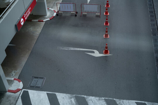 No entry sign, traffic cones and temporary barriers control vehicle access on parking road at shopping mall in Thailand. Safe traffic flow and restricted entry. Traffic management area. Parking safety