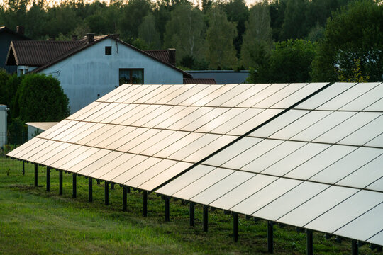 Dabrowa Gornicza, Poland - 23 August 2026: View of solar panels installed in a residential area with a house and trees in the background.