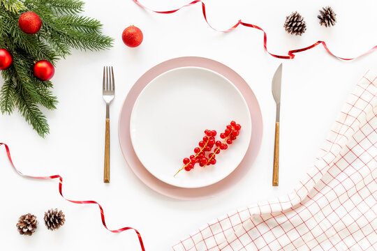Empty plate with fir tree branch and red colored decoration. Table setting top view