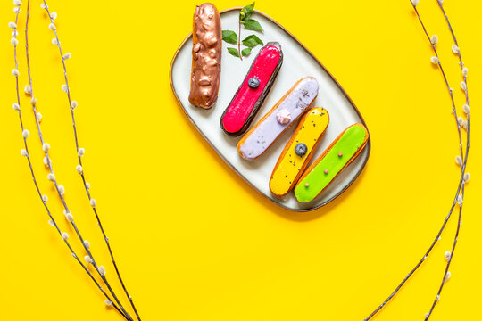 French eclairs served on plate - colorful artisan dessert composition with soft daylight, top view food photography