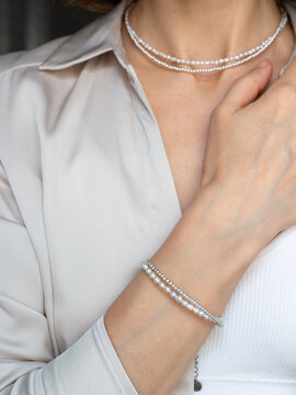 Fashion portrait of woman wearing gemstone jewelry necklace and bracelet - warm neutral aesthetic with natural beauty style