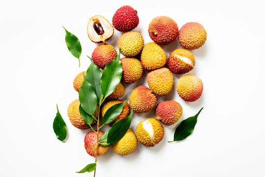 Fresh lychee fruit with green leaves, top view