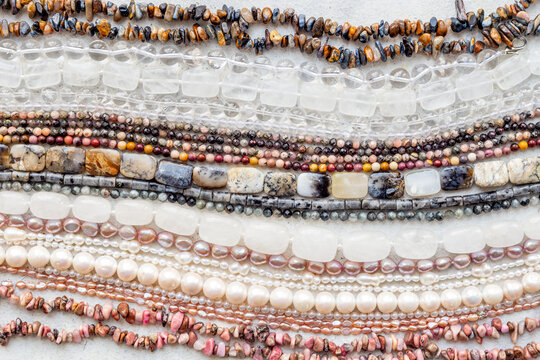 Precious and jewelry flat lay background. Lots of gemstones for necklace and bracelets, top view