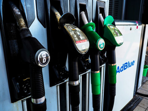 Close-up of fuel dispenser nozzles for diesel and unleaded gasoline at a MOL gas station.
