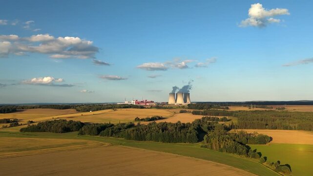 cooling towers of the Temelin nuclear power plant surrounded by rural summer landscape with fields and forests, Czech republic