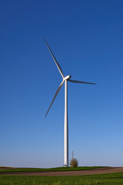 Wind turbines at sunset in green field &ndash; renewable energy, clean power, sustainable future.