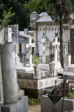 Patzcuaro, Mexico - 27 October 2021: View of stone crosses and ornate tombs in a historic cemetery during Day of the Dead preparations in Patzcuaro, Michoacan, Mexico.