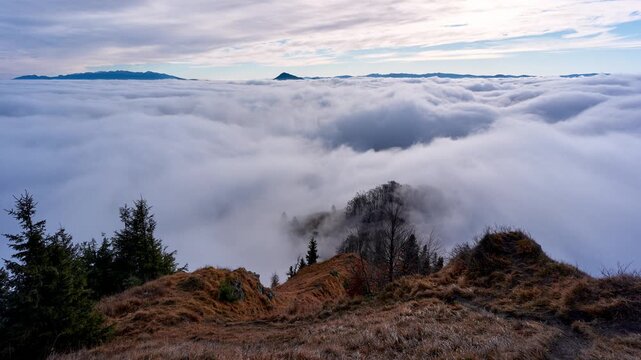 Timelapse of Thick Sea of Fog Rolling Over Valley Below Mountain Slope