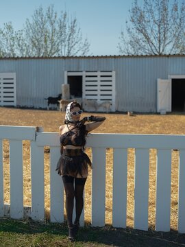 Asian woman in black lace lingerie posing behind white farm fence
