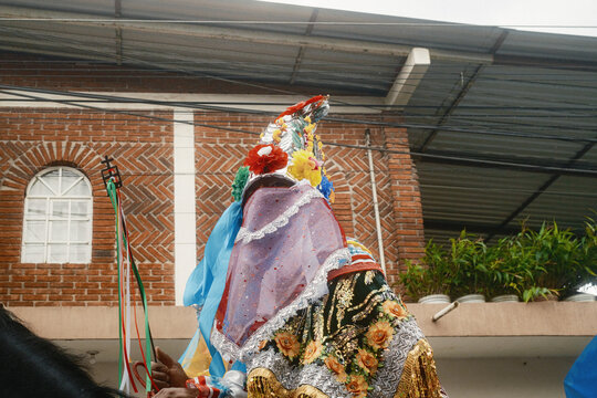 San Lorenzo, Michoacan, Mexico - 10 August 2026: View of a dancer in a traditional Moros y Cristianos costume with an ornate sequined headpiece and ribboned staff.
